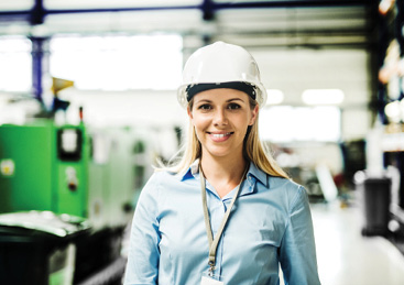 A portrait of an industrial woman engineer standing in a factory