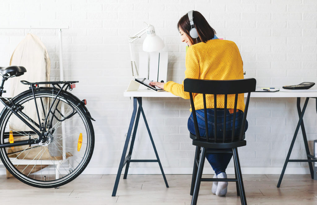 Freelance woman working in home office with laptop computer.