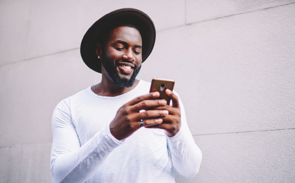 Cheerful man viewing mobile phone